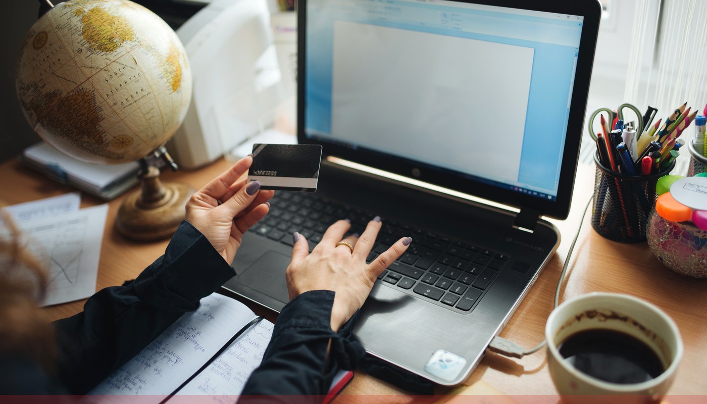 Notebook com cartão e anotações de orçamento para mapear assinaturas digitais recorrentes antes do fechamento da fatura